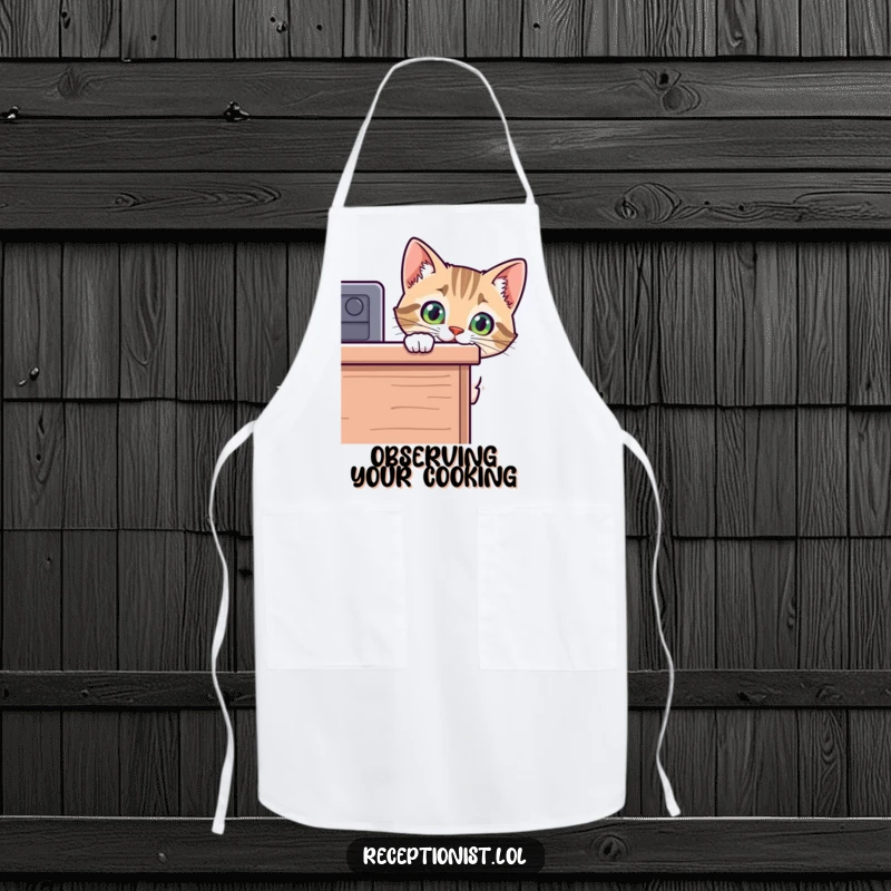 Funny cat apron with a curious kitten peeking over a desk, a humorous kitchen accessory for cat-loving cooks and bakers.